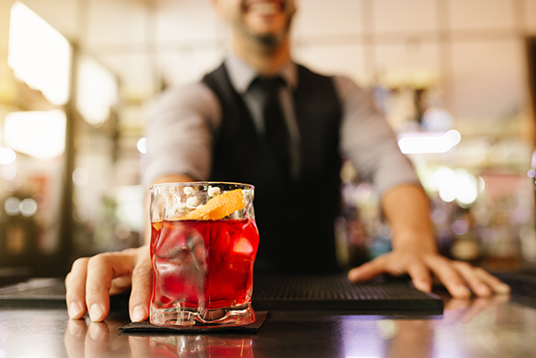 Expert barman is making cocktail at night club.